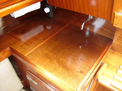 DE ORIGINALE bordplader i pantry-sektionerne er i praktisk, karrygult laminat. I denne Bianca 27 er de udført i lakeret mahogni. Bemærk også den fine, forkormede hane. 