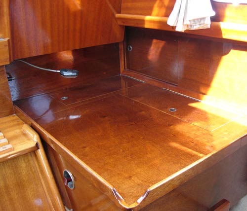 OGSÅ I bagbord side er de karrygule laminat-plader i pantry skiftet ud med fornemt, lakeret mahogni.